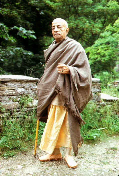 Śrīla Prabhupāda mosolyogva, összetett kézzel